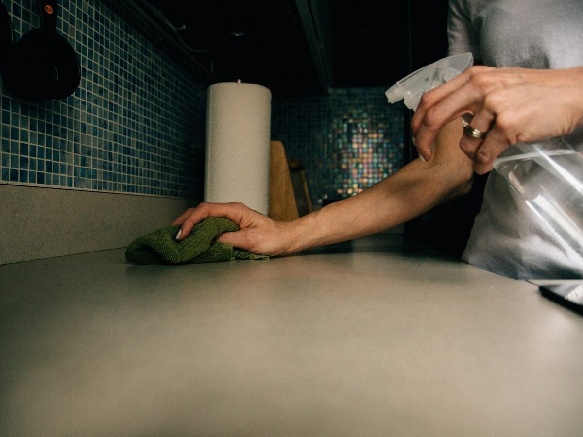 A shared kitchen worktop being wiped down